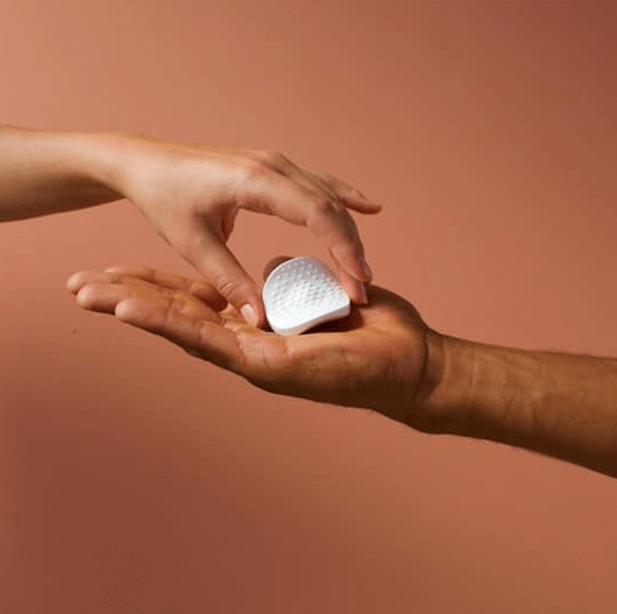 person handing a prolong device to her partner as a gift